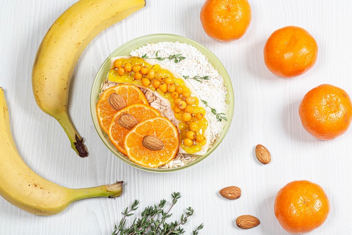 Muesli bowl with bananas, mandarines, and sea buckthorn