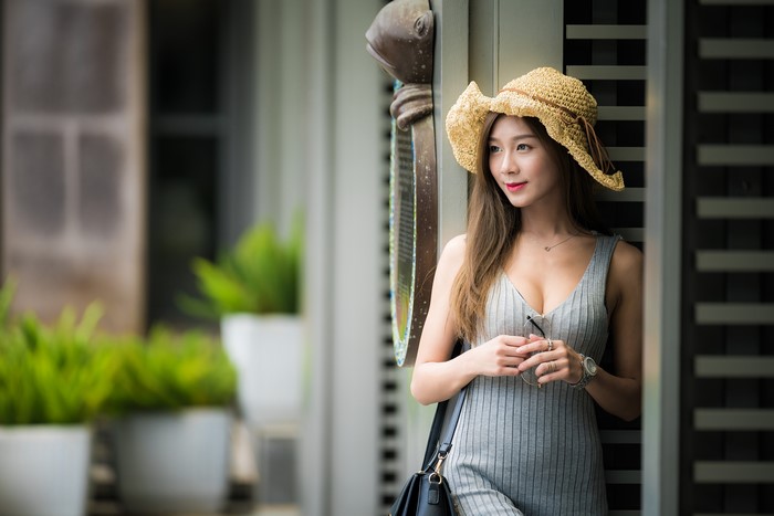 Asian woman in straw hat and grey dress