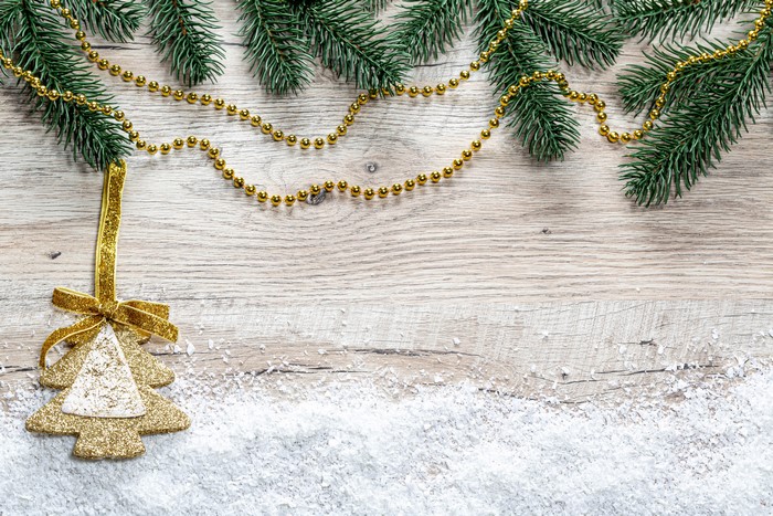 Christmas tree ornament with pine branches and beads on wood