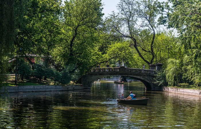 Boats on a canal under a bridge in a park