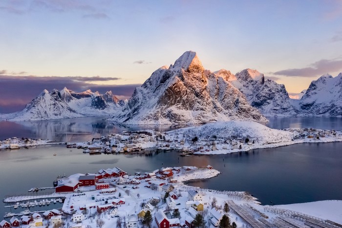 Snowy Lofoten village with mountains and bay