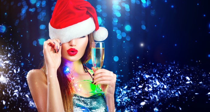 Woman in Santa hat holding champagne