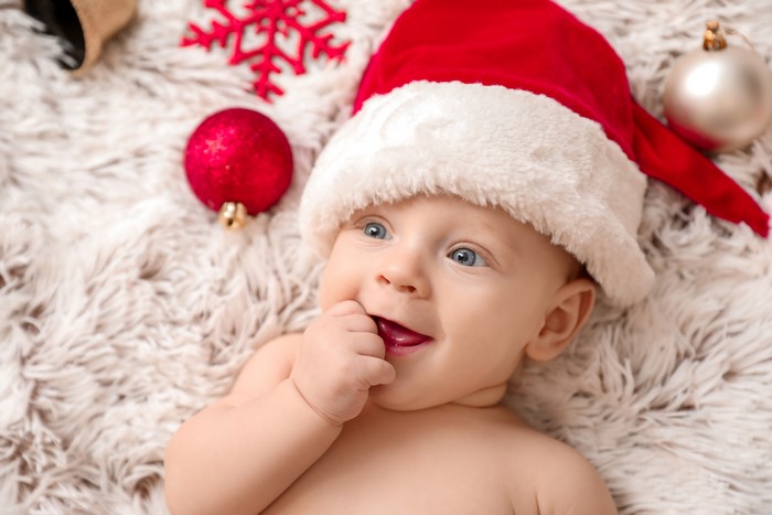 Baby in Santa hat with Christmas ornaments
