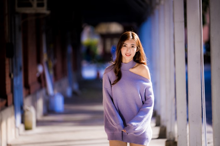 Asian woman with brown hair wearing a purple sweater