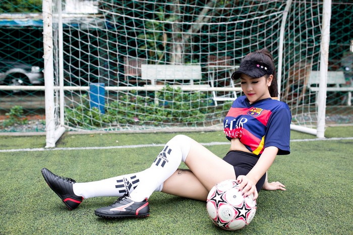 Asian woman in soccer uniform with ball