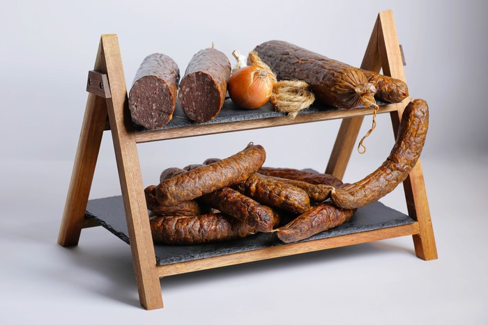 Sausages and Onion on a Wooden Stand