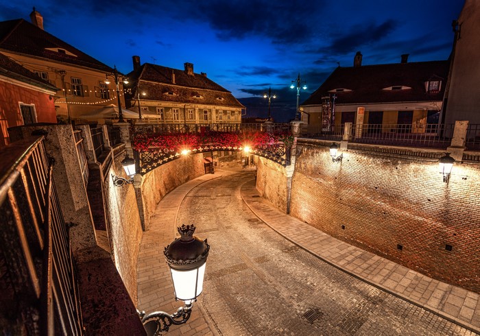 Cobblestone street and bridge in Sibiu, Romania at night