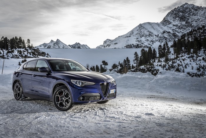 Blue Alfa Romeo Stelvio in snowy mountains