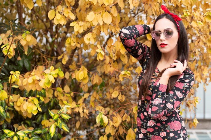 Woman with red bandana and floral dress posing