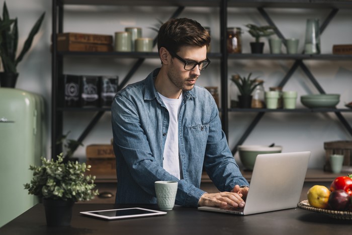 Man wearing glasses using a laptop