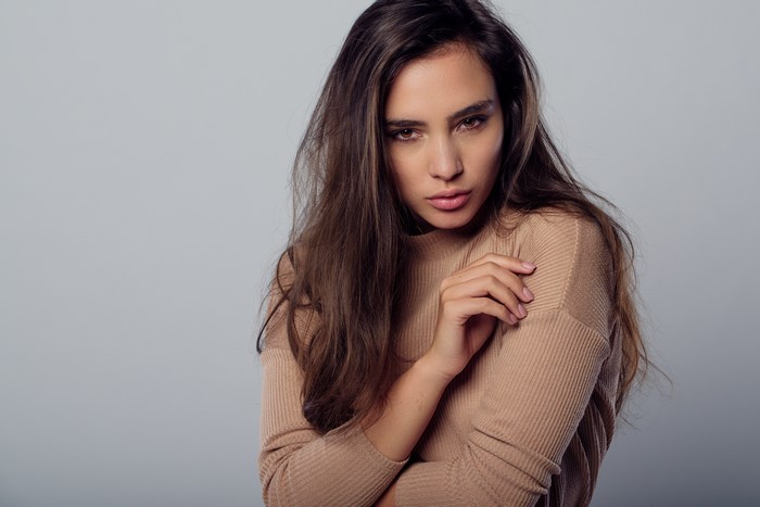 Woman in a brown sweater with long brown hair