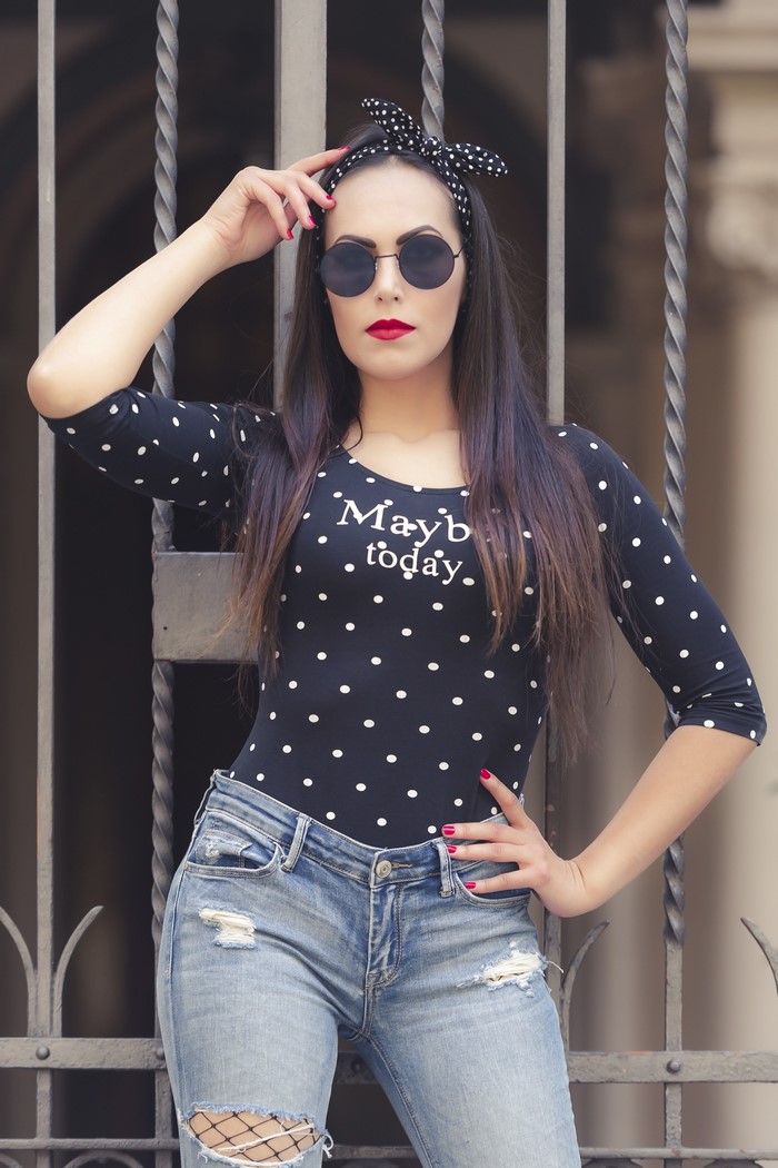 Woman with polka dot top and ripped jeans