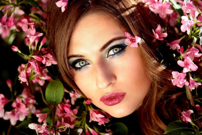 Woman with pink flowers and blue makeup