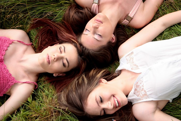 Three women lying on grass
