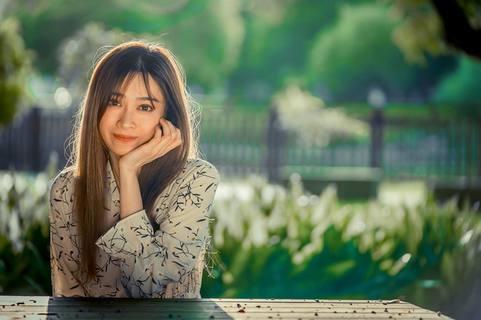Asian woman sitting at a table outdoors