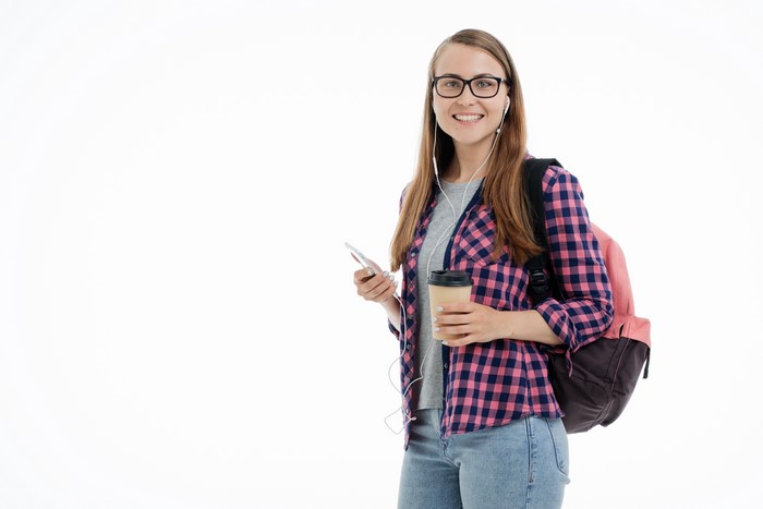 Young woman with backpack, phone, and coffee