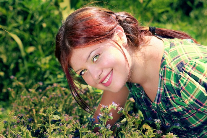 Redhead girl smiling in a garden