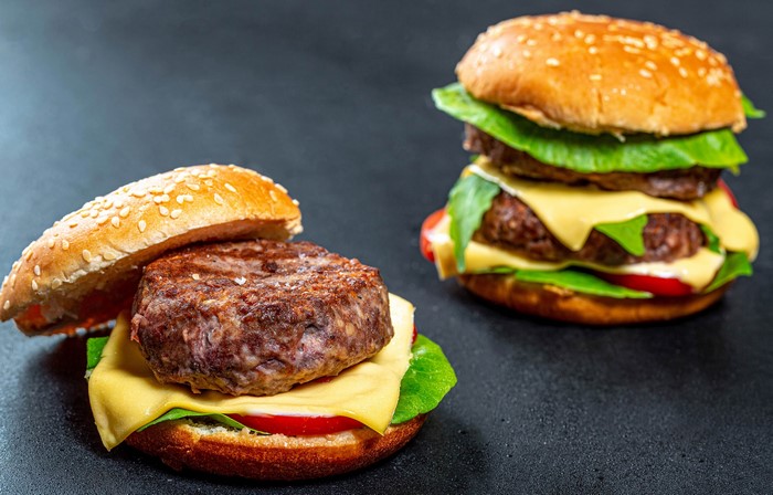 Two hamburgers with cheese and lettuce