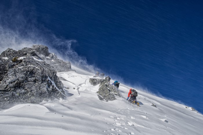 Mountaineers climbing a snowy mountain face