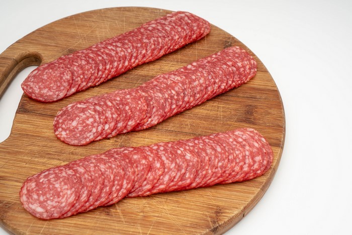 Sliced salami on a wooden cutting board
