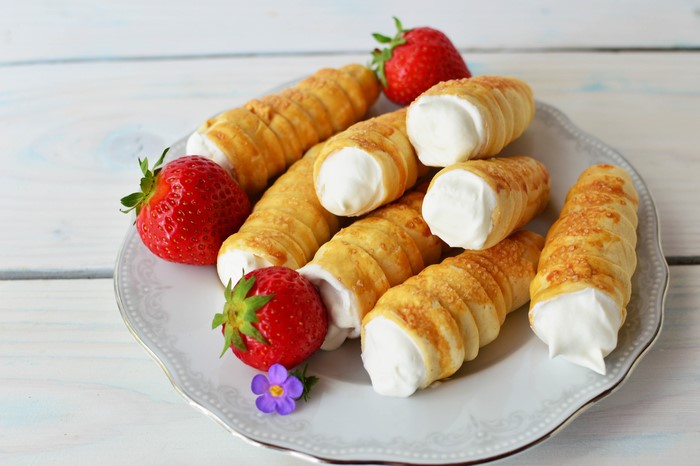 Cream horns with strawberries on a plate