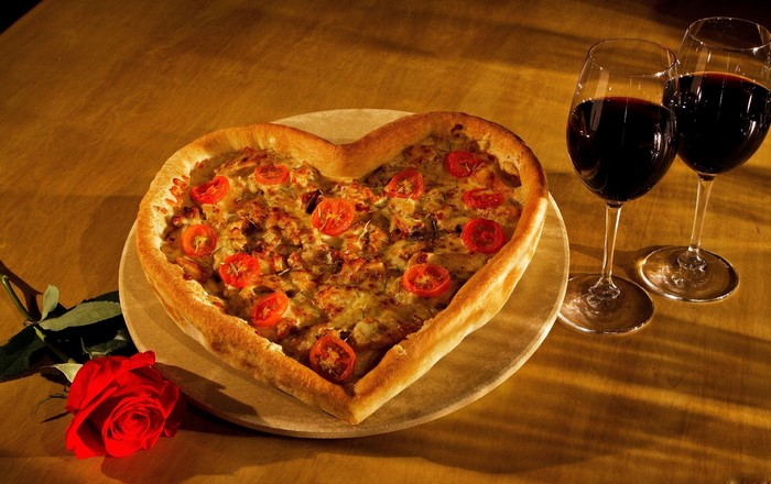 Heart-shaped pizza with tomatoes and red wine