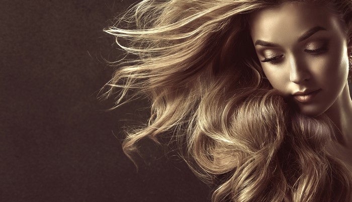 Woman with flowing dark blonde hair by Sofia Zhuravets