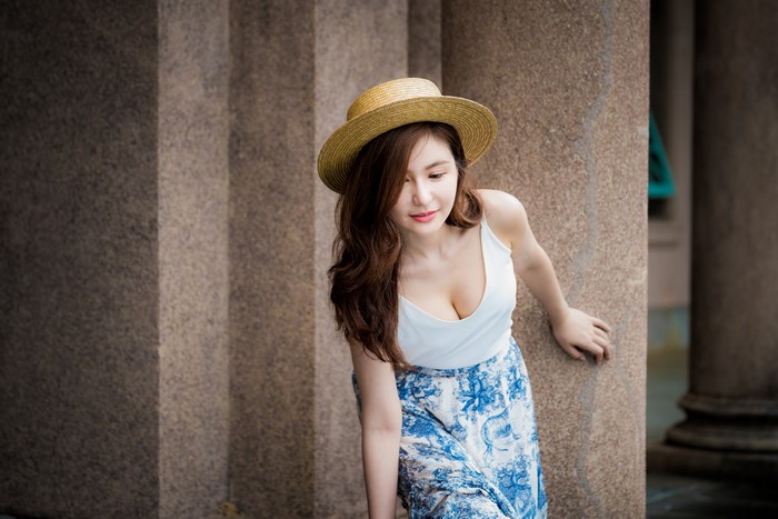 Asian woman with brown hair wearing a hat and skirt