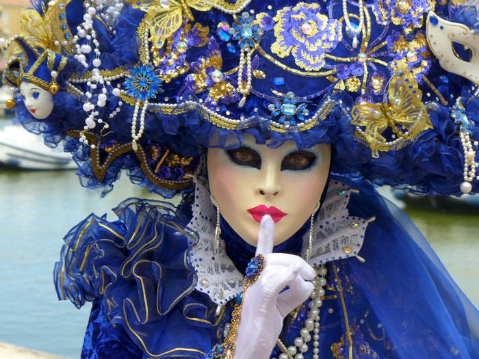 Woman in elaborate blue and gold Venetian carnival costume and mask