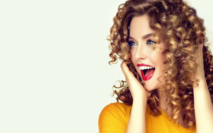 Woman with curly brown hair and red lips