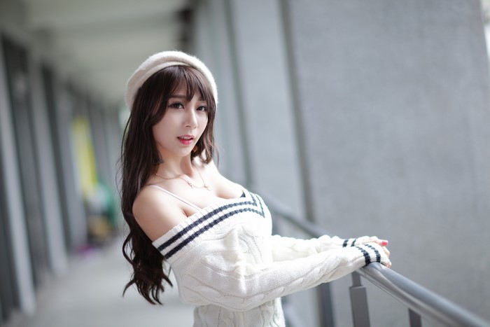 Asian woman wearing a beret and sweater