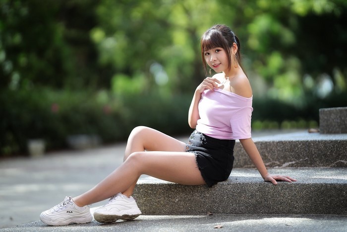 Asian Woman Sitting in Shorts Outdoors