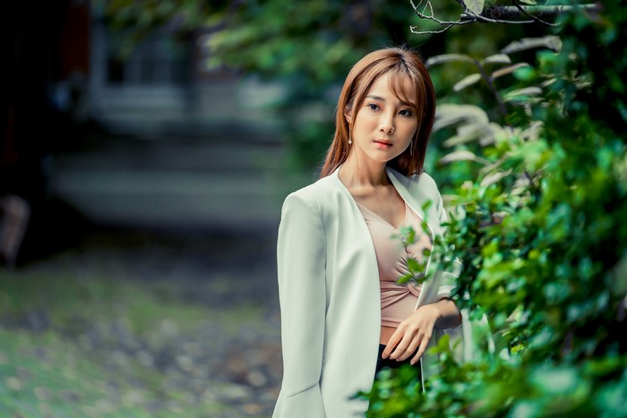 Asian woman with brown hair in a white blazer