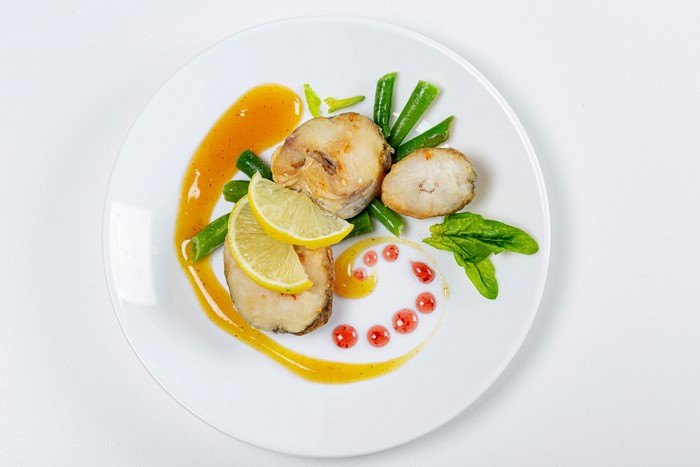 Fish with lemon and green beans on a plate