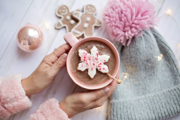 Hot chocolate with snowflake cookie and winter hat
