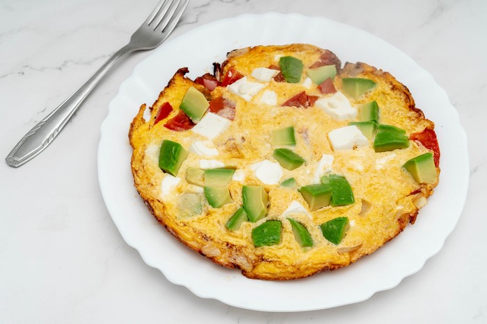 Omelet with Avocado and Cheese on a Plate with Fork