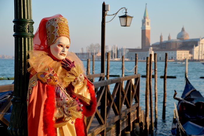 Venice Carnival Masked Person by Canal with Gondolas