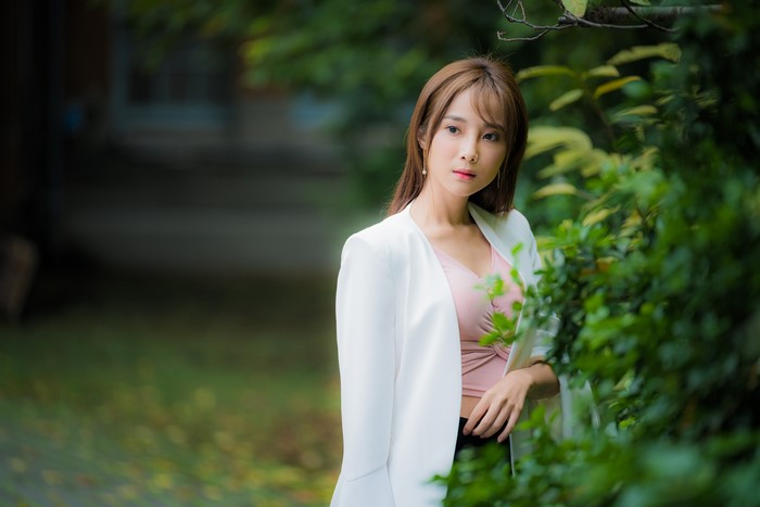 Asian woman with brown hair in a white blazer