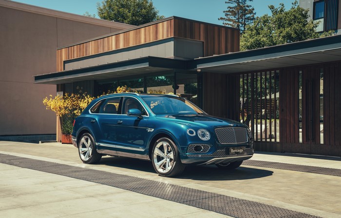 Blue Bentley Bentayga Hybrid parked in front of a modern building