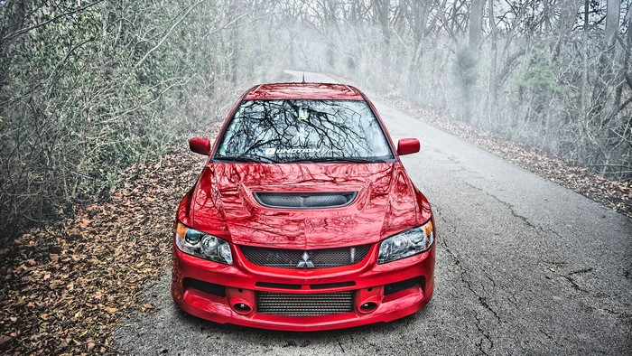 Red Mitsubishi Lancer Evolution IX on a foggy road
