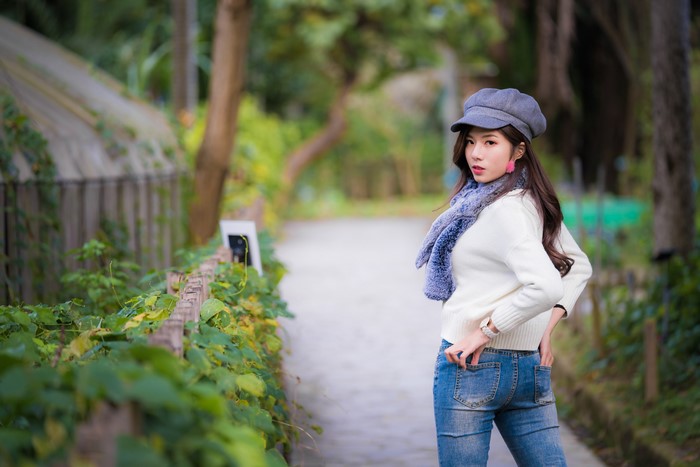 Asian woman in jeans and sweater with scarf