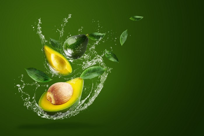 Avocado with water splash and leaves