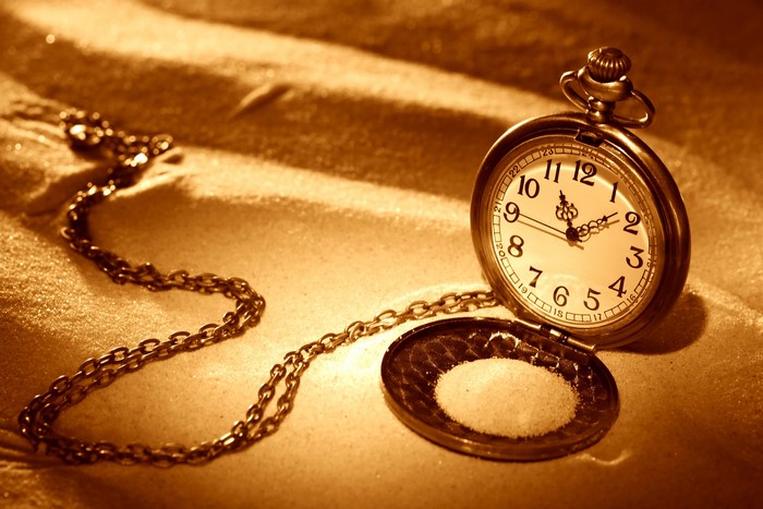 Pocket watch with chain on sand