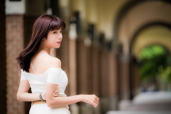 Asian woman with brown hair in white top