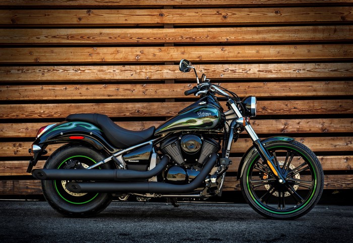 Kawasaki Vulcan Custom motorcycle parked against wooden wall