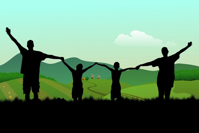 Family holding hands in a field