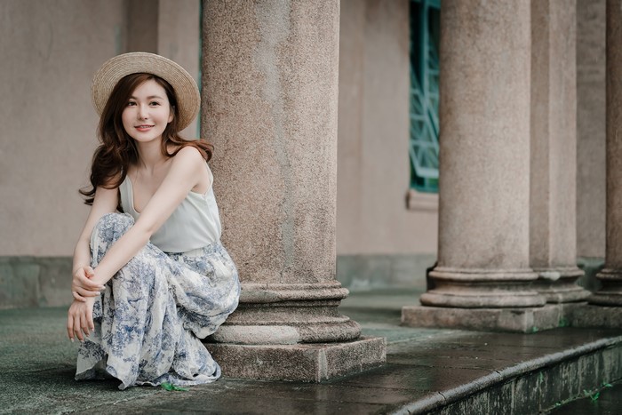 Asian woman with brown hair wearing a hat