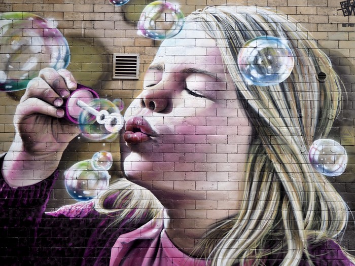 Graffiti of a girl blowing soap bubbles