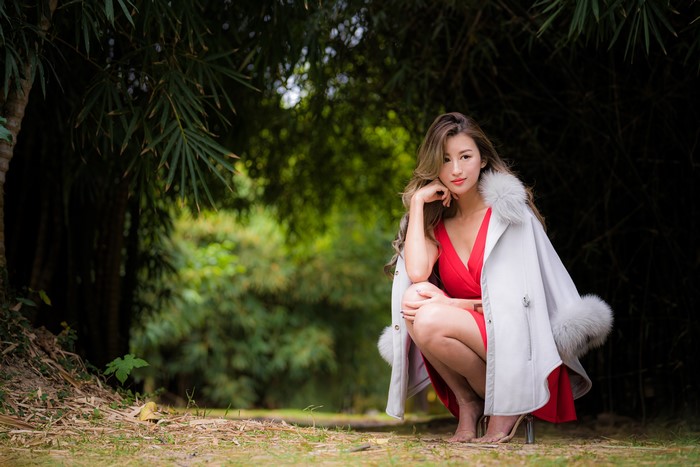 Asian woman in red dress and fur-trimmed coat