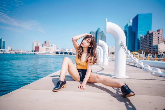 Asian woman sitting on waterfront